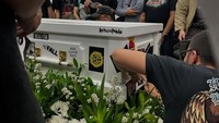 Kerabat yang datang ikut menempelkan stiker band di peti jenazah Ricky Siahaan. Foto: dok. Instagram Sammy Bramantyo (@sam_bram)
