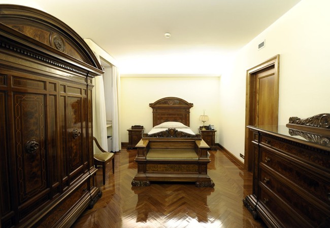 Foto yang diambil pada Maret 2013 ini memperlihatkan penampakan kamar tidur di salah satu suite. Interior kayu bergaya klasik mendominasi. (Foto: Eric VANDEVILLE/Gamma-Rapho via Getty Images)