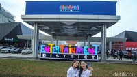 Pengunjung berfoto di depan Entertainment District, PIK 2, Jumat (25/4/2025).