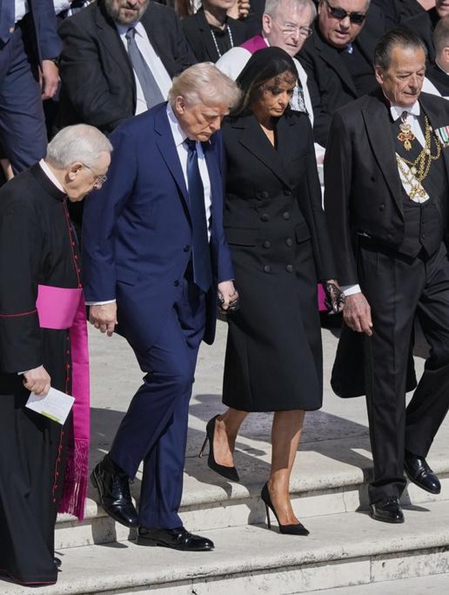 Presiden Amerika Serikat Donald Trump hadir ditemani Ibu Negara Melania Trump. Sang FLOTUS tampil mengenakan gaun trench coat hitam dilengkapi veil berbahan lace. Foto: AP/Gregorio Borgia
