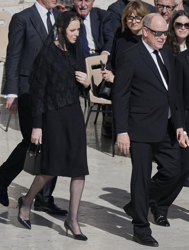 Mewakili Kerajaan Monako, Pangeran Albert hadir didampingi Putri Charlene. Sang putri tampil elegan memakai shift dress hitam lengan panjang serta veil. Dia tampak menjinjing clutch Prada berwarna senada. Foto: AP/Gregorio Borgia