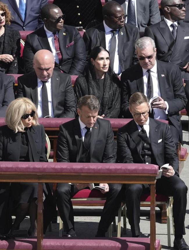 Presiden Prancis Emmanuel Macron dan Ibu Negara Brigitte Macron tak ketinggalan hadir memberikan penghormatan terakhir untuk paus pertama dari Amerika Latin tersebut. Brigitte tampil stylish dengan gaun hitam dipadu jaket a la militer dan stocking hitam. Foto: AP/Markus Schreiber