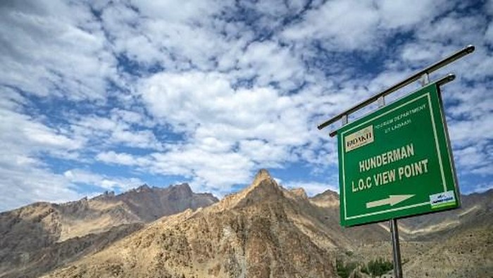 This photograph taken on July 27, 2024 shows a sign board near Line of Control (LOC) - the border between India and Pakistan, at the Hunderman village in Kargil district. Once the ancient trade route over the Himalayan passes of Hunderman brought communities together, but the rugged peaks today are used as fortifications by nuclear-armed rivals India and Pakistan. (Photo by Tauseef MUSTAFA / AFP) / TO GO WITH India-Pakistan-Conflict FOCUS