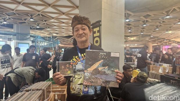 Penggerak komunitas Record Store Day di Bali, Andhika Gautama, menunjukkan koleksi filisan fisiknya di Living World, Denpasar, Minggu (27/4/ 2025). (Foto: Fabiola Dianira/detikBali)
