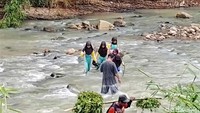 Sejumlah siswi Madrasah Miftahul Falah dari Kampung Cigirang, Desa Neglasari, Sukabumi, menyeberangi sungai dipandu warga. Mereka bertaruh keselamatan demi tetap bisa bersekolah