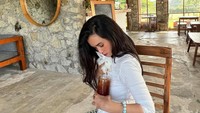 Ayushita terlihat tengah santai di kafe sambil menggendong kelinci putih. Kali ini ia ‘ditemani’ segelas es teh. Foto: Instagram ayushita