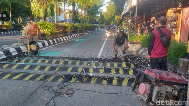 Petugas membongkar polisi tidur di Jalan Pemuda Klaten yang tuai sorotan, Minggu (27/4/2025).