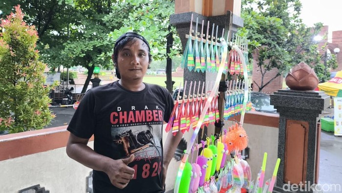 Rendi bersama mainannya saat berjualan di Alun-alun Kejaksan Kota Cirebon