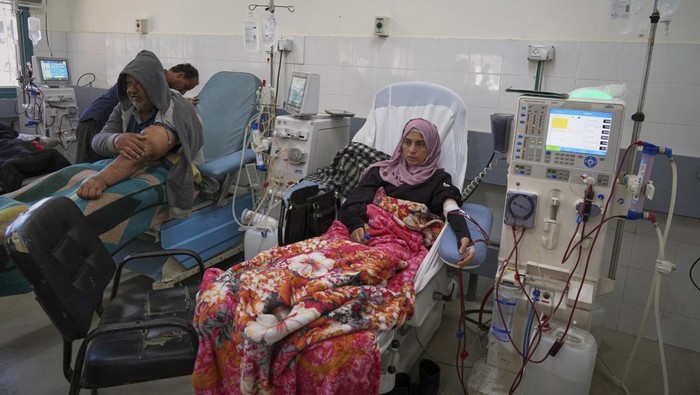 Wasem Attiya pushes his father, Mohamed, 54, in a wheelchair as they head to Shifa hospital in Gaza City for a dialysis session, Monday, April 14, 2025. (AP Photo/Jehad Alshrafi)