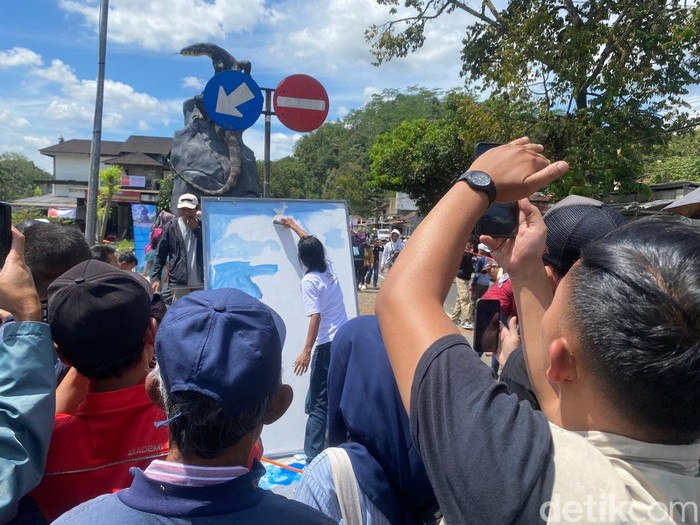 Seniman pembuat patung biawak live drawing di lokasi patung biawak di Desa Krasak, Kecamatan Selomerto, Wonosobo, Minggu (27/4/2025).