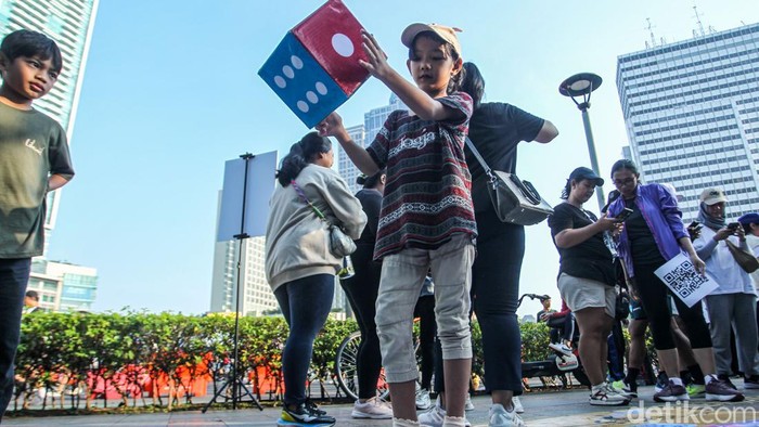 Serunya Main Ular Tangga Saat Lepas Lelah di CFD Warga mengikuti permainan ular tangga saat Car Free Day, Jakarta, Minggu (27/4/2025).