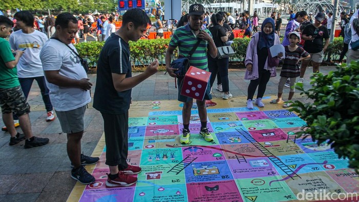 Serunya Main Ular Tangga Saat Lepas Lelah di CFD Warga mengikuti permainan ular tangga saat Car Free Day, Jakarta, Minggu (27/4/2025).