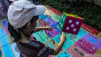 Warga yang usai melakukan olahraga turut berpartisipasi dalam permainan ini, nantinya mereka secara bergilir menggunakan dadu yang menentukan langkah mereka.