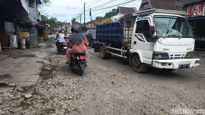 Truk yang mengakut muatan tambang pasir dan tanah melintas di jalan rusak Bontoramba.