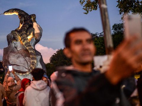 Seniman pembuat tugu patung biawak Rejo Arianto (kedua kiri) berfoto bersama warga di Desa Krasak, Wonosobo, Jawa Tengah, Minggu (27/4/2025). Tugu patung biawak setinggi tujuh meter tersebut kini dikunjungi ribuan warga dari berbagai kota setiap harinya usai sebelumnya viral di berbagai media sosial karena kemiripan patung dengan biawak aslinya. ANTARA FOTO/Muhammad Bagus Khoirunas/YU