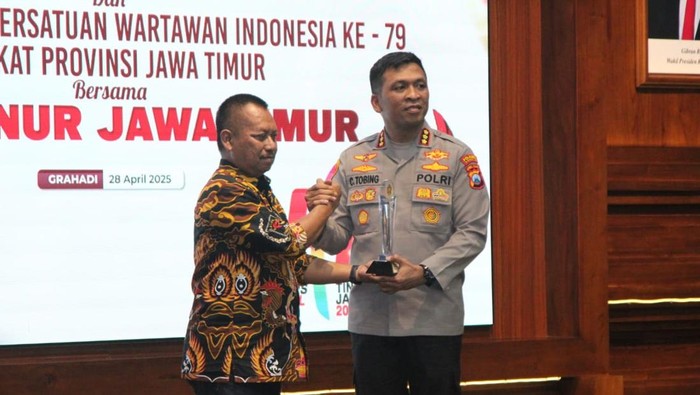 Kapolresta Sidoarjo Kombes Christian Tobing menerima trofi dari Ketua PWI Jatim Lutfil Hakim