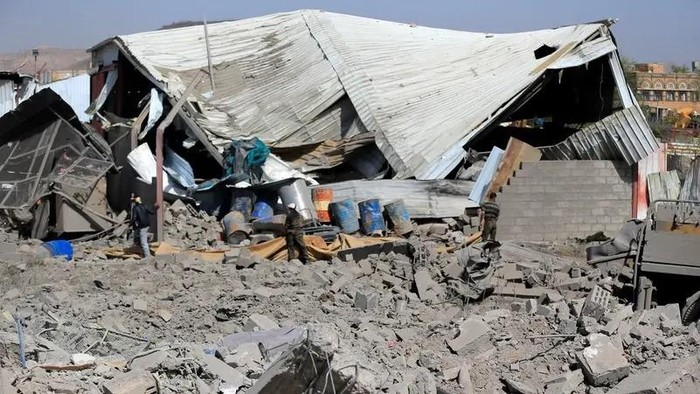 People assess the damage following overnight strikes attributed by the Yemeni media to the United States, in the Houthi-controlled capital Sanaa on April 27, 2025. (AFP)