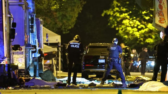Vancouver Police forensics officers investigate the scene of a suspect vehicle and bodies of victims lying covered on the ground, after it drove into a crowd at a Lapu Lapu day block party, in which police say multiple people were killed and injured, in Vancouver, Canada April 27, 2025. REUTERS/Chris Helgren Purchase Licensing Rights