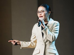 Tampil rapi dan elegan, Prilly tampak mengenakan celana panjang hitam bahan dipadukan dengan kaus hitam dan blazer krem. Ra,nutnya terlihat simple dengan gaya sleen bun. Foto: Instagram/@prillylatuconsina96