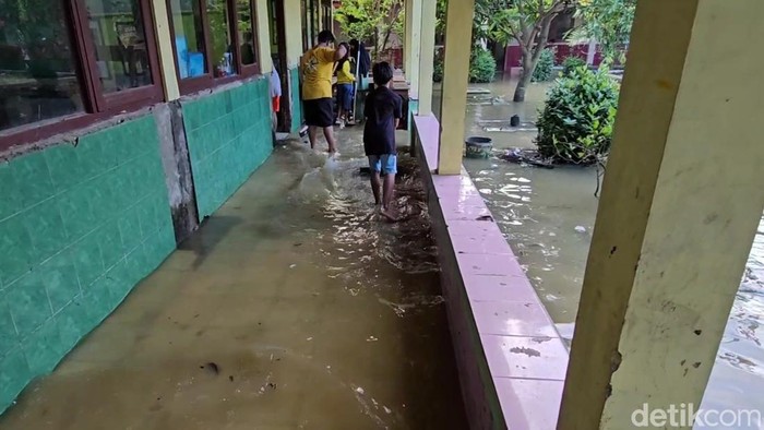 Siswa SDN Ketitang Wetan kerja bakti membersihkan sekolah yang kebanjiran di Desa Ketitang Wetan, Kecamatan Batangan, Pati, Senin (28/4/2025).