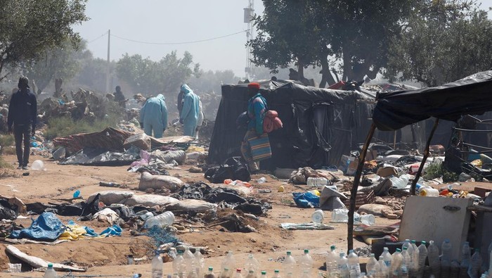 Tunisia Bakar Kamp Migran di Sfax, Ribuan Diusir A member of Tunisian health authorities walks near a tent, as Tunisian authorities have dismantled makeshift camps housing sub-Saharan African migrants, in Amra, Sfax, Tunisia April 24, 2025. REUTERS/Zoubeir Souissi