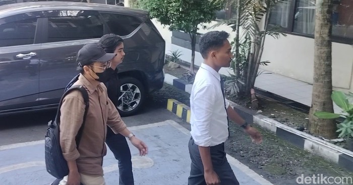 Dokter YA (baju coklat bertopi hitam) saat datangi panggilan penyidik
