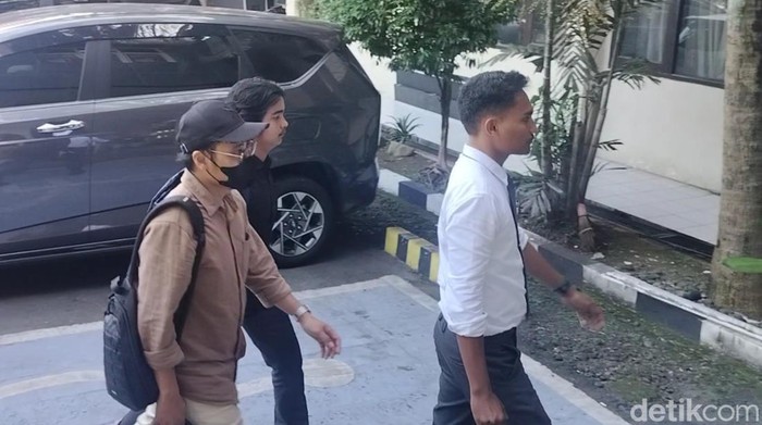 Dokter YA (baju coklat bertopi hitam) saat datangi panggilan penyidik