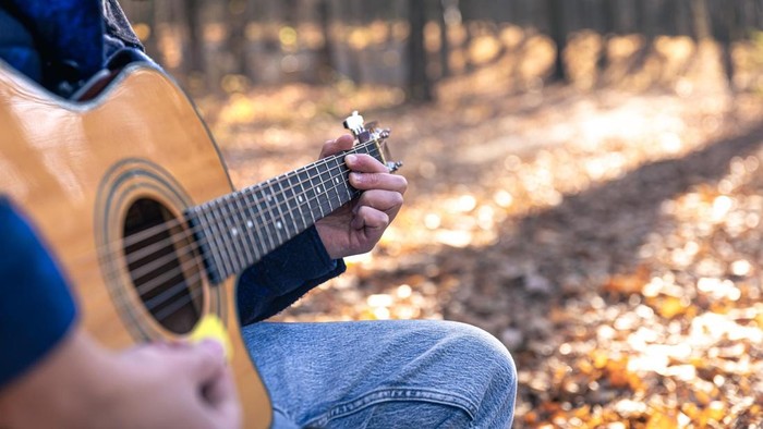 Pria memainkan Lagu Perpisahan Sedih untuk Sekolah, Teman Kerja, hingga Purna Tugas menggunakan gitar.