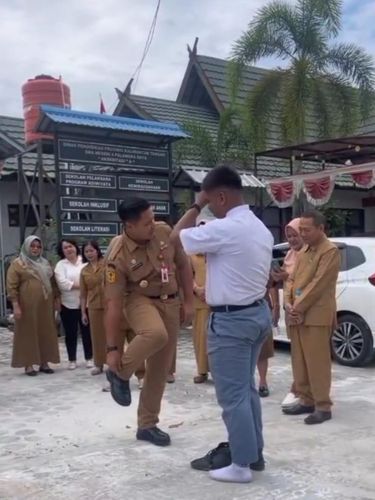 Momen Kadisdik Kalteng Reza Prabowo memberikan sepatu yang dipakainya ke pelajar yang sepatunya rusak