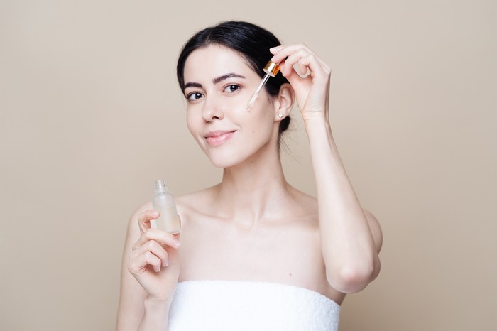 Ilustrasi wanita memakai serum skincare