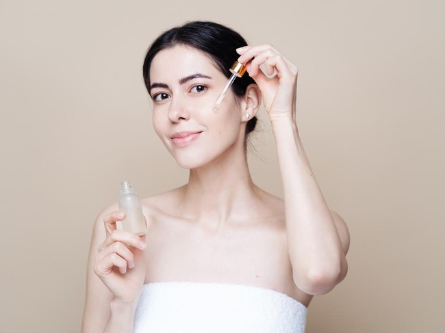 Ilustrasi wanita memakai serum skincare
