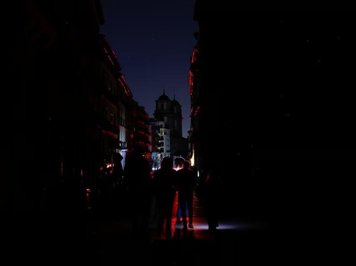 People use flashlights as they walk in the dark during a nationwide power outage in Madrid, Spain, April 28, 2025. REUTERS/Susana Vera Purchase Licensing Rights