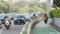 Pengendara motor masih sering melintasi jalur sepeda, seperti yang terlihat di Jalan Jenderal Sudirman, Jakarta, Rabu (29/4/2025). Meski sudah ada marka, pelanggaran tetap terjadi.  