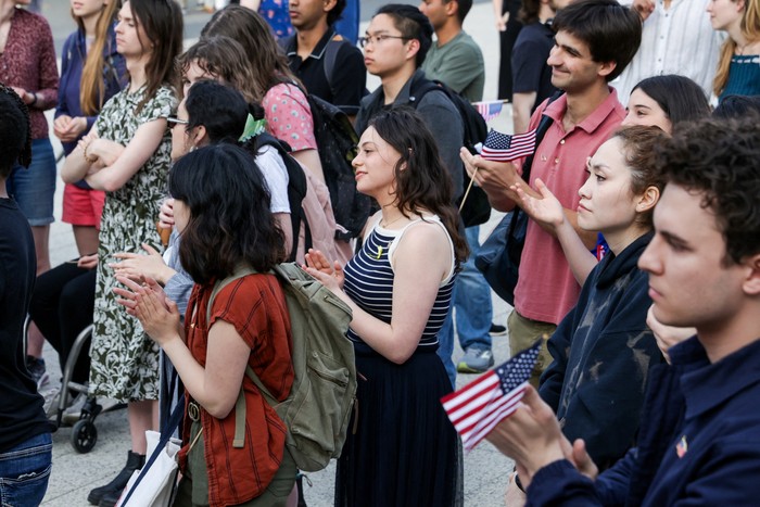 A demonstrator holds a U.S. flag across their chest at a Harvard Stands United Rally organized by Students for Freedom at Harvard University in Cambridge, Massachusetts, U.S. April 29, 2025.  REUTERS/Taylor Coester