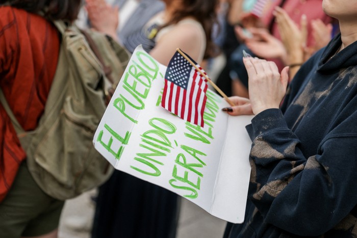 A demonstrator holds a U.S. flag across their chest at a Harvard Stands United Rally organized by Students for Freedom at Harvard University in Cambridge, Massachusetts, U.S. April 29, 2025.  REUTERS/Taylor Coester