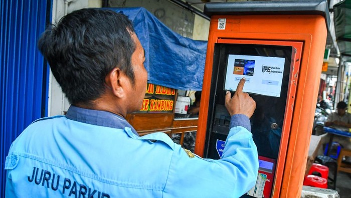 Juru parkir mengoperasikan mesin terminal parkir elektronik di Jalan Sabang, Jakarta, Selasa (29/4/2025).  Dinas Perhubungan Provinsi DKI Jakarta mencatat pendapatan dari terminal parkir elektronik (TPE) mengalami penurunan yaitu sebesar Rp13 miliar pada tahun 2020 menjadi Rp8,9 miliar pada tahun 2024 yang disebabkan rusaknya sebanyak 137 mesin TPE dari total 201 mesin TPE yang ada di Jakarta. ANTARA FOTO/Sulthony Hasanuddin/rwa.