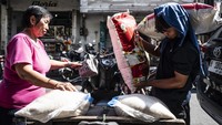 Pekerja (kanan) memindahkan karung beras ke sepeda motor di kawasan Pasar Dargo, Semarang, Jawa Tengah.