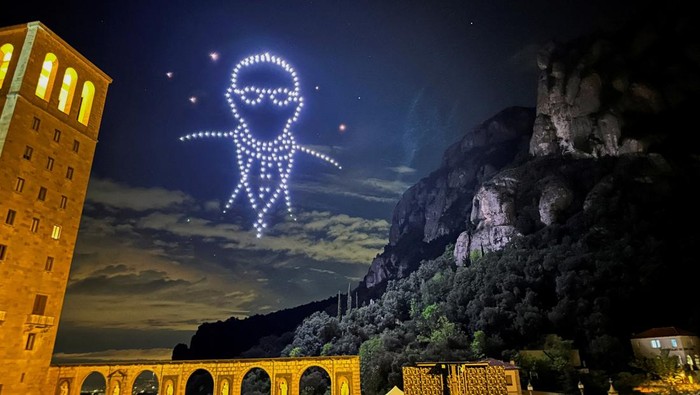 Ratusan Drone Membentuk Sosok Paus Fransiskus di Langit Barcelona A view shows drones lighting the sky, creating an image of the late Pope Francis, by Flock Drone Art, on the Montserrat Abbey, to mark 1000th anniversary of its foundation, in Montserrat, near Barcelona, Spain April 27, 2025. REUTERS/Nacho Doce REFILE - CORRECTING
