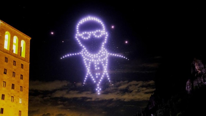 Ratusan Drone Membentuk Sosok Paus Fransiskus di Langit Barcelona A view shows drones lighting the sky, creating an image of the late Pope Francis, by Flock Drone Art, on the Montserrat Abbey, to mark 1000th anniversary of its foundation, in Montserrat, near Barcelona, Spain April 27, 2025. REUTERS/Nacho Doce REFILE - CORRECTING