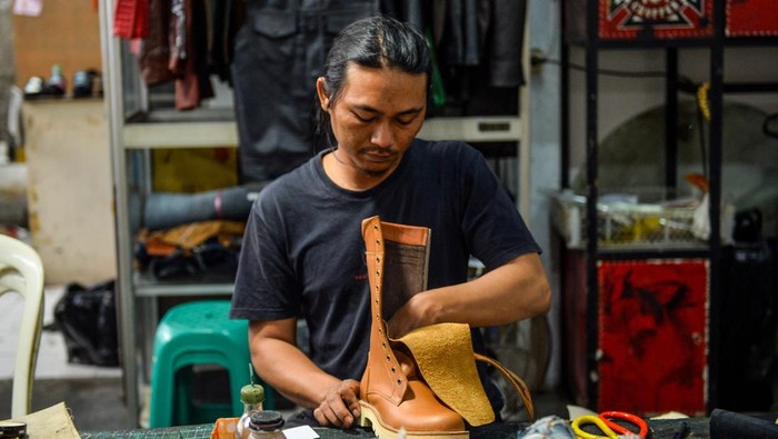 Perajin menyelesaikan produksi sepatu boots di rumah produksi Tegep Boots di Pasirluyu, Bandung, Jawa Barat, Rabu (30/4/2025). Tegep Boots yang berdiri pada Tahun 1997 tersebut memproduksi sepatu boots dengan bahan baku kulit telah memiliki pasar tetap di mancanegara seperti Inggris, Perancis, Hongkong dan Australia, dijual dari harga Rp3,5 juta hingga ratusan juta tergantung dari jenis bahan yang di produksi. ANTARA FOTO/Raisan Al Farisi/Spt.