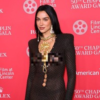 Gaun tersebut merupakan bagian dari koleksi ready-to-wear musim gugur 2025, menampilkan siluet body-con yang membalut tubuh dengan efek material seperti kulit ular berwarna cokelat gelap. Foto: Getty Images