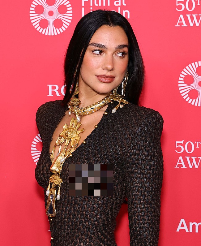 Siluetnya begitu melekat dan mengilap, memberi kesan sensual sekaligus berani. Tanpa bra dan hanya mengenakan thong hitam sebagai dalaman, penampilan Dua Lipa ultra-seksi namun terkesan artistik. Foto: Getty Images