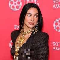 Siluetnya begitu melekat dan mengilap, memberi kesan sensual sekaligus berani. Tanpa bra dan hanya mengenakan thong hitam sebagai dalaman, penampilan Dua Lipa ultra-seksi namun terkesan artistik. Foto: Getty Images