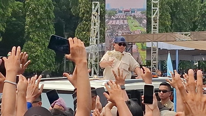 Presiden Prabowo Subianto membagikan baju serta topi kepada buruh saat meninggalkan perayaan May Day di Monas.