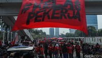Di sisi lain, sejumlah peserta aksi membentangkan spanduk besar tepat di pagar DPR RI. Spanduk itu berisi pesan dan kritik keras terhadap pemerintah serta dukungan terhadap perjuangan buruh.