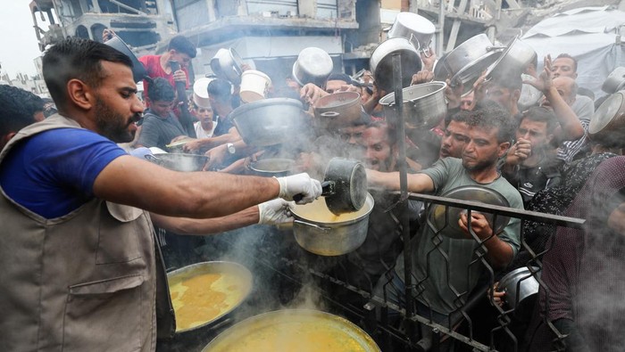 Dapur Umum di Gaza Terancam Tutup gegara Stok Makanan Habis Palestinians wait to receive food cooked by a charity kitchen, in Beit Lahiya, northern Gaza Strip, April 28, 2025. REUTERS/Mahmoud Issa TPX IMAGES OF THE DAY