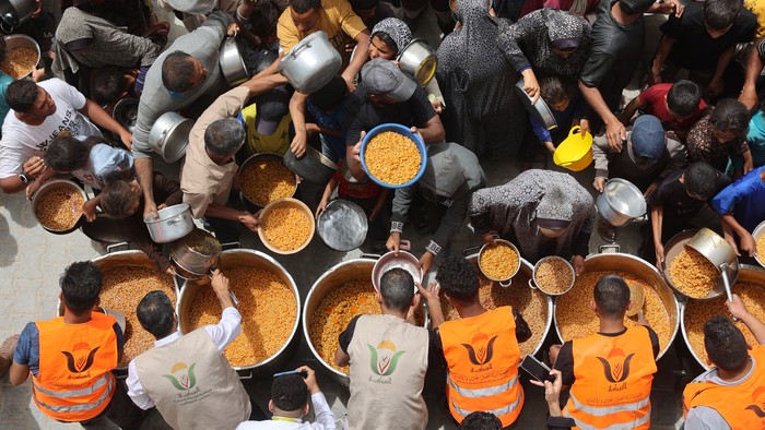 Palestinians queue for a hot meal at a charity kitchen in Gaza City on April 30, 2025. The UN food agency, one of the main providers of food assistance in the besieged Palestinian territory said on April 25 it had 