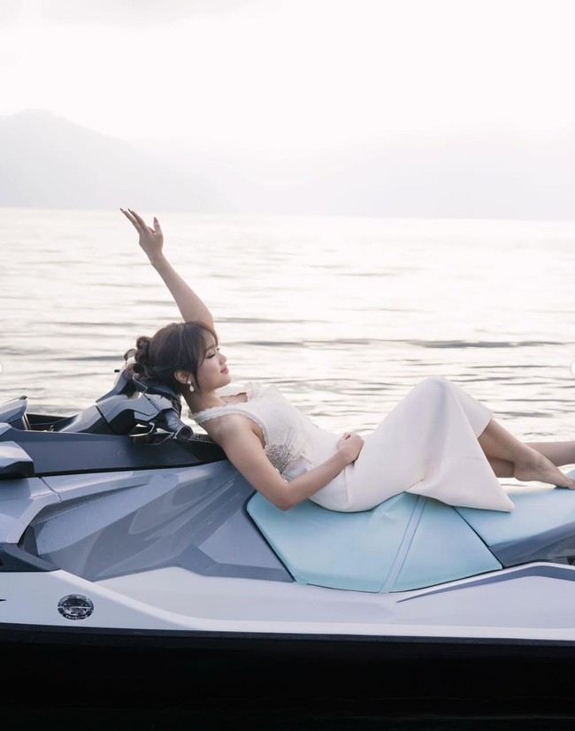 Alih-alih tampil sporty, Fuji justru memilih bergaya femini dengan mengenakan dress putih. Sambil tiduran di atas jetski, Fuji memamerkan pose santainya. Foto: Instagram/@fuji_an