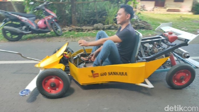 Gio menunjukan mobil Tamiya hasil rakitan dari barang bekas yang bisa dikendarai.