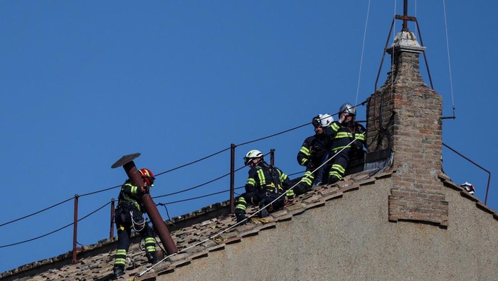 Firefighters work on the roof of the Sistine Chapel to set a chimney, ahead of the conclave, at the Vatican May 2, 2025. REUTERS/Stoyan Nenov